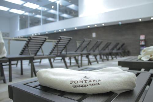 a towel sitting on top of a table with chairs at Hotel Fontana Vrnjačka Banja in Vrnjačka Banja