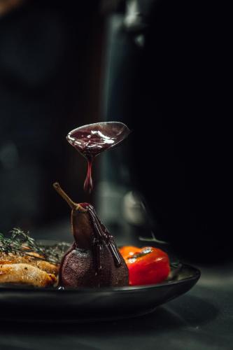 a plate of food with a spoon of chocolate sauce at Rossano Boutique Hotel & Ristorante in Ansbach