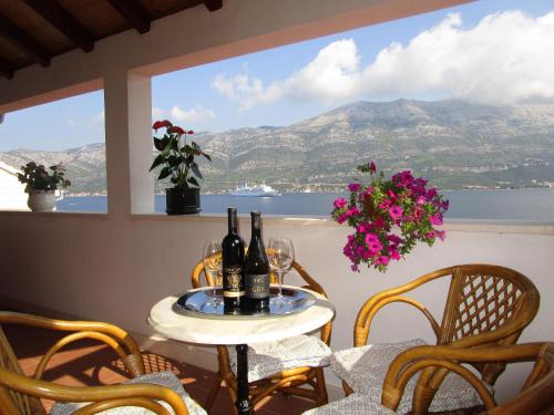 a table with wine bottles on a balcony with a view at Vila Tea in Korčula