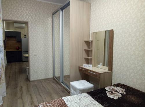 - une chambre avec un lit, un lavabo et un miroir dans l'établissement Apartment on Ostrovskogo 59a, à Sotchi