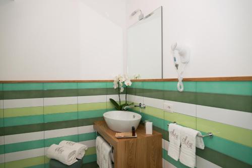 a bathroom with a white sink and green and white stripes at Sorrento Stylish Rooms in Sorrento