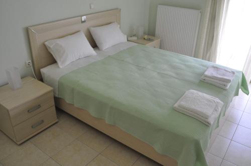 a bedroom with a large bed with two towels on it at Feel free in Paleo Tsifliki