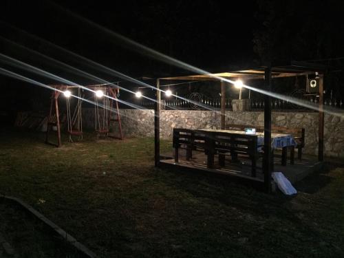 a picnic table under a tent with lights at night at Suluca Homes in Kérynia
