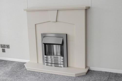 a fireplace in a room with white walls at Molland Manor House Bed & Breakfast in Sandwich