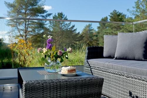 a table with a vase of flowers on a patio at Düne 74 in Ostseebad Karlshagen