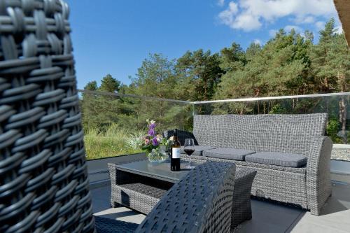 a patio with a table and two wicker chairs at Düne 74 in Ostseebad Karlshagen