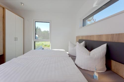 a bedroom with a large bed and a window at Düne 74 in Ostseebad Karlshagen