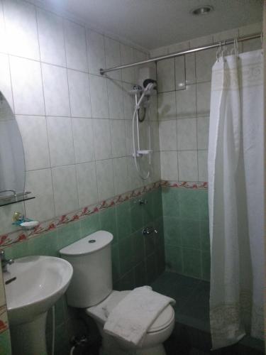 a bathroom with a toilet and a sink and a shower at Casa Micarosa Hotel in Manila