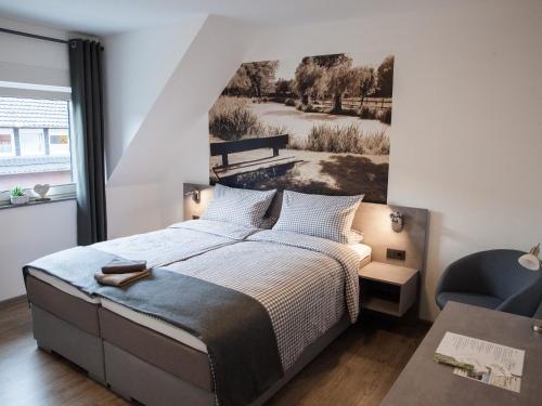 a bedroom with a bed with a picture on the wall at Pension Dalinghaus in Vörden
