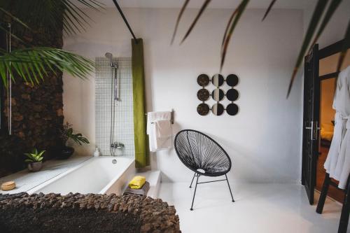 a bathroom with a tub and a chair in it at Finca Malvasia Rural Estate & Vineyard in Tías