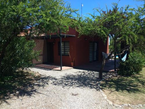 a red building with trees in front of it at Cabañas Quinco in Merlo