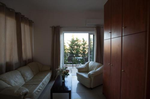 a living room with a couch and a large window at Cavallari Palace Hotel Suites in Athens