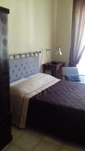 ラ・スペツィアにあるMarina's Houseのベッドルーム1室(ベッド1台、ランプ付きテーブル付)