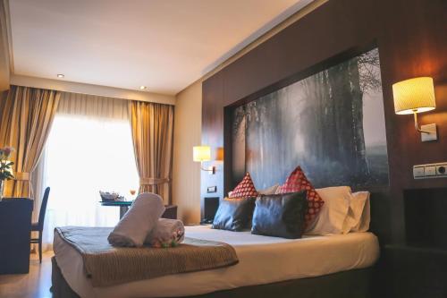 a bedroom with a bed with pillows on it at Oh Nice Ulises Ceuta in Ceuta