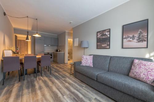 a living room with a couch and a dining room at LakeSide Apartments Seefeld in Seefeld in Tirol