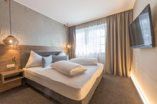 a bedroom with a large bed with a flat screen tv at LakeSide Apartments Seefeld in Seefeld in Tirol