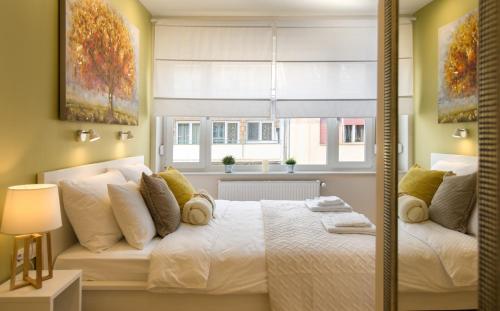 sypialnia z białym łóżkiem i oknem w obiekcie MirÓ Studio Apartments Zagreb w Zagrzebiu