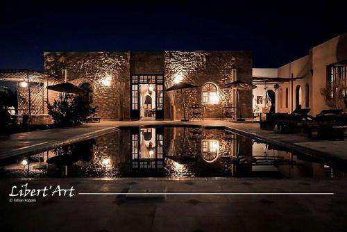 a house with a swimming pool at night at Libert'Art in Essaouira