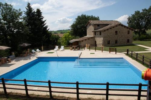 a large swimming pool in front of a building at BorgoPratole CountryHouse in Cingoli
