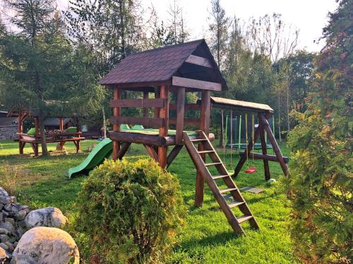 a wooden playground with a ladder and a slide at Cabana din Groapa Frumoasa in Râşnov