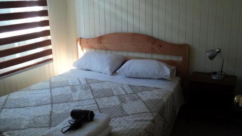 a bedroom with a bed with a purse on it at Cabañas Arlenne in Valdivia