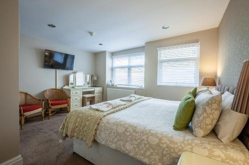 a bedroom with a bed and a desk and a television at The Hotel Balmoral - Just for Adults in Torquay