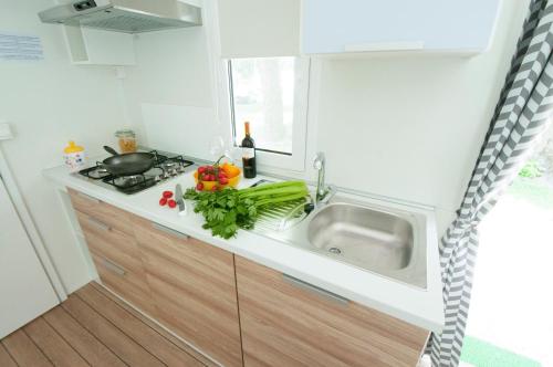 a small kitchen with a sink and a stove at Camping Serenissima in Malcontenta