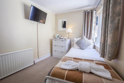 a bedroom with a bed with towels on it at The Hotel Balmoral - Just for Adults in Torquay