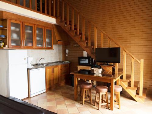 a kitchen with a staircase with a table and stools at The Wave Baleal in Baleal