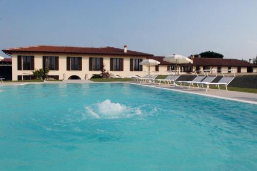 a large swimming pool with chairs and a building at Agriturismo Le Vai in Bardolino