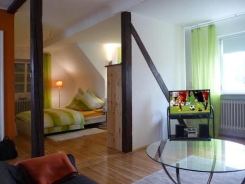 ein Wohnzimmer mit einem Bett und einem Glastisch in der Unterkunft NetteMaisonette in Saarbrücken