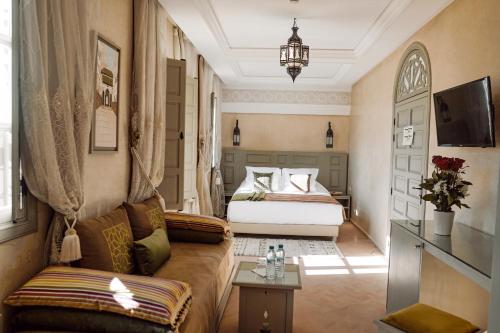 Habitación de hotel con cama y sofá en Riad Zidania en Meknès