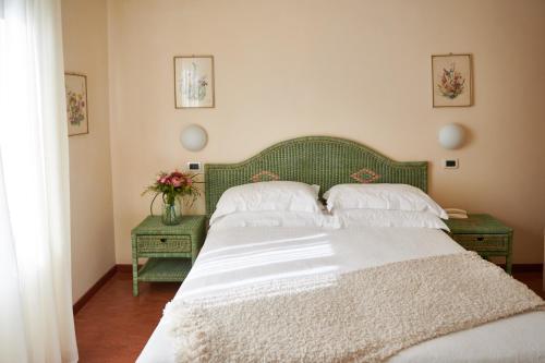 a bedroom with a large bed with a green headboard at Villa Arizona in Milano Marittima
