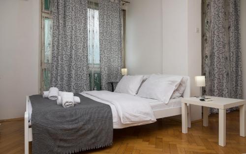 a small bedroom with a bed and a table at Apartman Panorama Glavna ulica in Užice