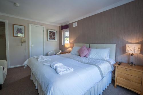 a bedroom with a large bed with towels on it at The Hotel Balmoral - Just for Adults in Torquay