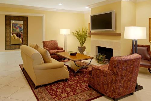 a living room with two chairs and a fireplace at La Posada Hotel in Laredo