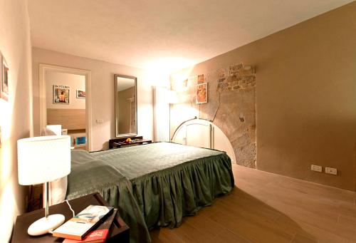 een slaapkamer met een bed en een stenen muur bij New Galileo in Pisa