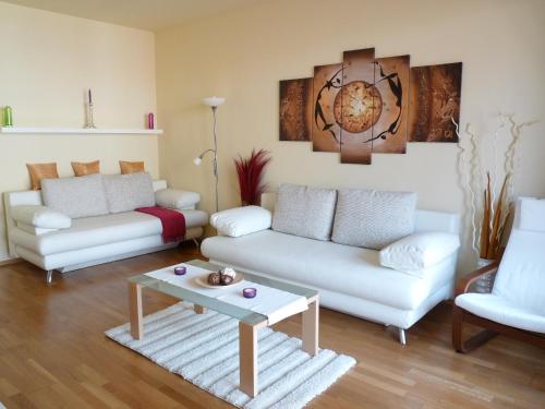 a living room with two white couches and a table at Trendy Deluxe Apartments in Budapest