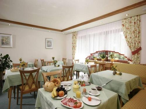 オーバーハルマースバッハにあるPension Waldfriedenのテーブルと椅子があり、食べ物が置かれているレストラン