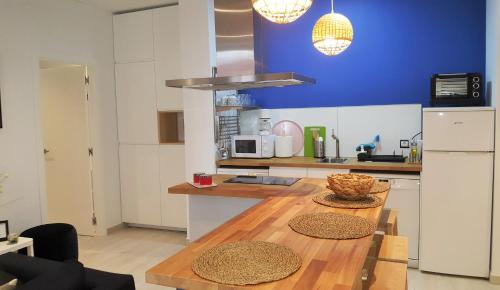 a kitchen with a wooden table and a blue wall at La Casa de Mencía AT-47-44 in Valladolid