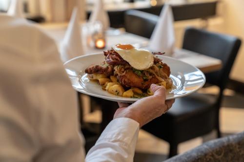 a person is holding a plate of food at Hotel Werk II in Bocholt