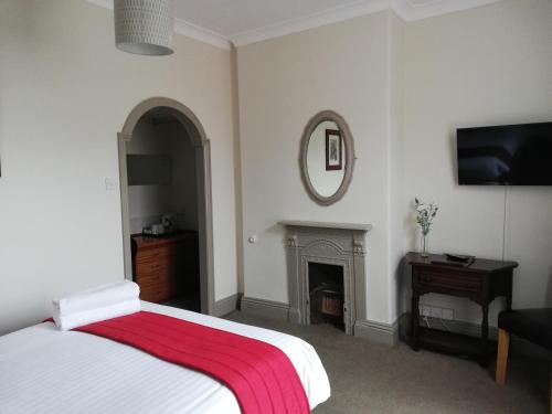 a bedroom with a bed with a red blanket on it at The Claremont in Woodhall Spa
