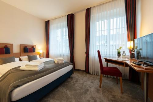 Habitación de hotel con cama y escritorio con ordenador en Hotel Werk II en Bocholt