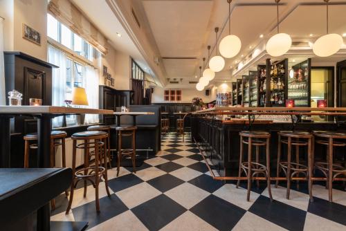 a bar with a checkered floor and bar stools at Hotel Werk II in Bocholt