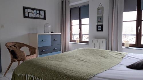 une chambre avec un lit, une chaise et des fenêtres dans l'établissement Little Suite - Louise, à Lille