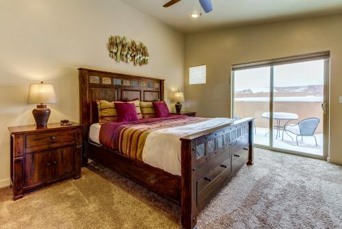 a bedroom with a bed and a sliding glass door at Rim Vista 9A8 in Moab