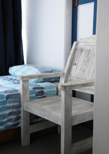 a pair of wicker chairs sitting next to a bed at Mr Pell's House Self-Catering Accommodation in Jeffreys Bay