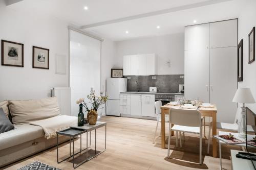 a white living room with a couch and a table at Art Studios by LoftAffair in Kraków