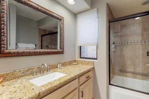 a bathroom with a sink and a shower and a mirror at McCormick Lakeside Retreat in Scottsdale
