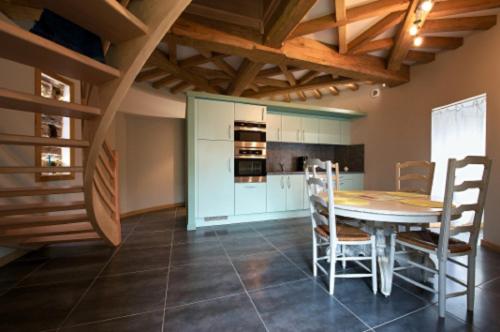 une cuisine avec une table et des chaises dans une pièce dans l'établissement Gite Le Grand Manoir, à Servon